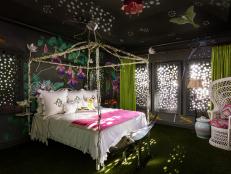 Designers Lori Deeds and Cece Bowman of Palm Beach-based Kemble Interiors describe this dreamy bedroom as "a bit fantastical." Continuing a trend for hand-painted murals, this room features exotic passion flowers in the design to drive home the Eden reference. Laser-cut shutters create dappled, raindrop-like light filtering into the bedroom. An Astroturf floor and embroidered bees on the wallpaper continue the "night garden" motif. 