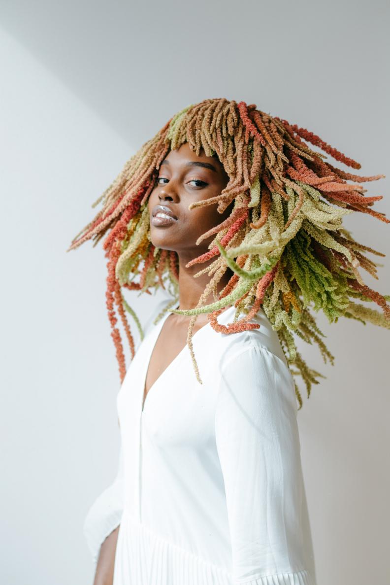 This “natural hair” wig is made with hanging amaranthus in three shades. A plastic skullcap is used for the base then the blooms were attached row by row using floral adhesive. As seen in the book 'The Art of Wearable Flowers.'