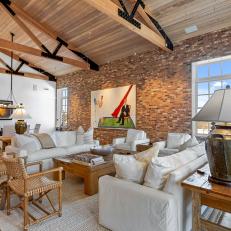 Rustic Great Room With Vaulted Ceilings and a Brick Accent Wall