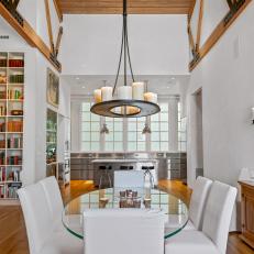 Open Dining Area Features Glass Dining Table and a Black Chandelier