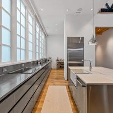 Modern Kitchen With Stainless Steel Cabinets and a Marble-Topped Island