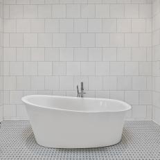 White Tiled Bathroom With Freestanding Tub and Chrome Fixtures