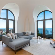 Bright Living Room With Gray Sectional and Arched Windows