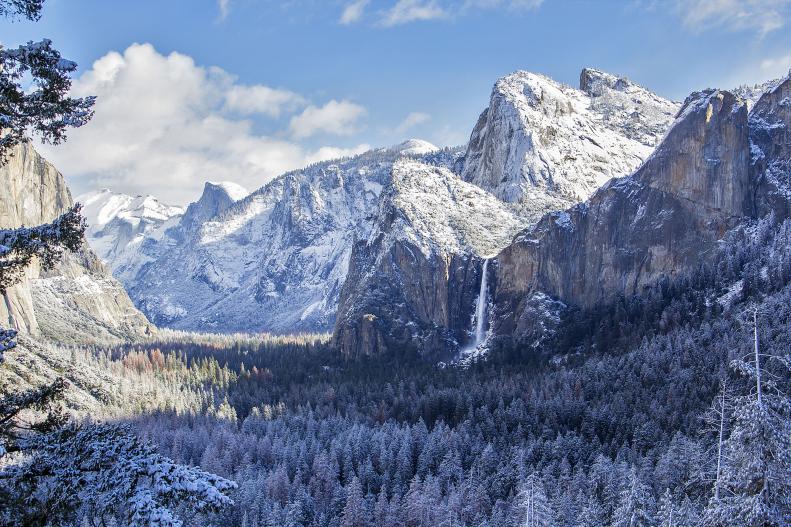 A snow-dipped Yosemite Valley with waterfalls and Half Dome