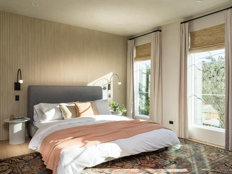 This main bedroom features a fluted wall and neutral decor.