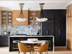 This eat-in kitchen features black paint and midcentury modern lights.