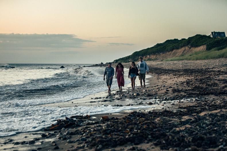 People walking along a beach at dusk