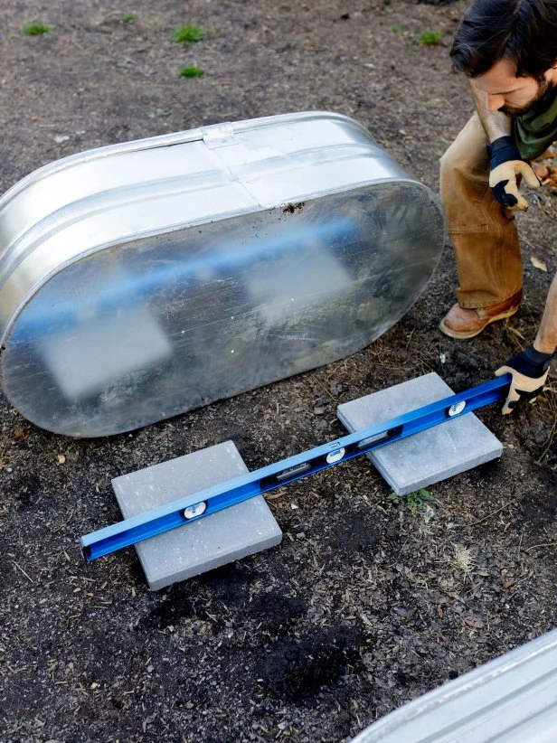 Blocks are leveled to go under galvanized tub to make raised plant bed.