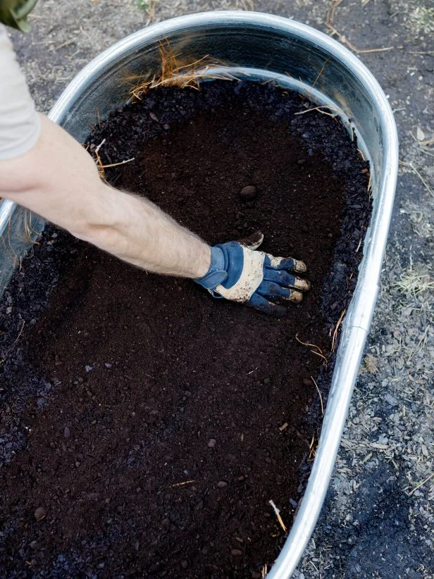 Spreading the first layer of dirt for our raised plant beds. 