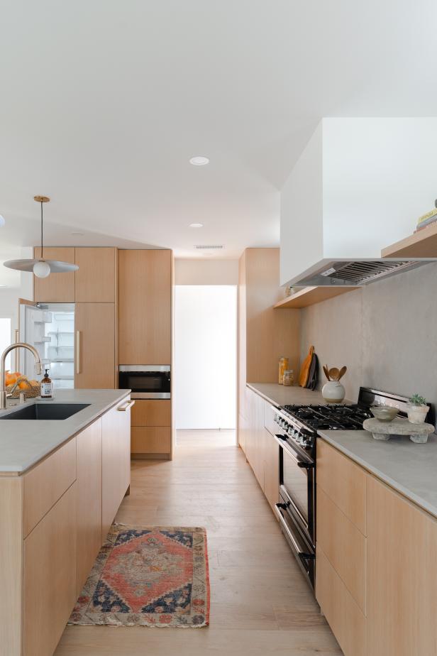 A kitchen with white oak cabinets and limestone backsplash