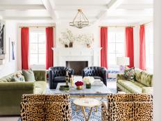 Bold, Eclectic Living Room With Red Drapes, Green Sofas, and Leather and Leopard Print Chairs 