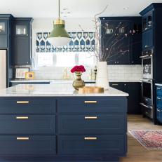 Contemporary Kitchen With Navy Cabinets, Marble Countertops and Opulent Bronze Hardware