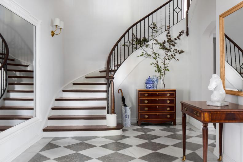 Foyer Features a Staircase and Black and White Tile