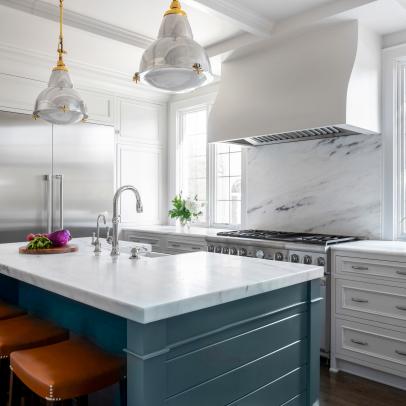 Bright Kitchen Features a Blue Island and Marble Countertops
