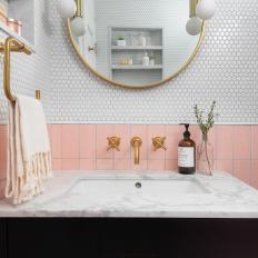 Pink and White Bathroom With Brass Mirror
