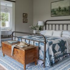 Rustic Farmhouse Bedroom With Iron Bedstead, Quilt and Heirloom Chest