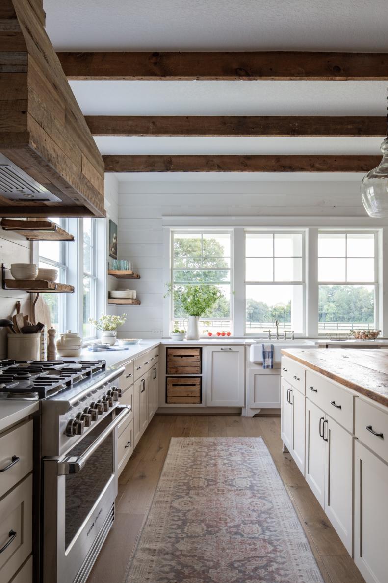 A white farmhouse kitchen features weathered wood, an antique runner.
