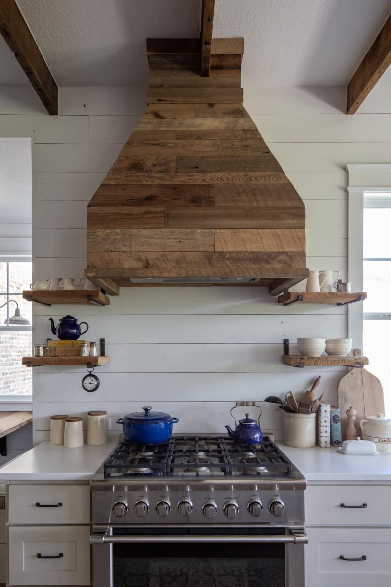 Farmhouse kitchen has reclaimed wood hood and steel range.
