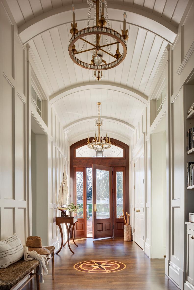 White hallway with arched ceiling and compass rose on floor.