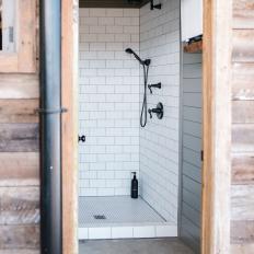 Bathroom Features a Shower With Subway Tile and Black Fixtures