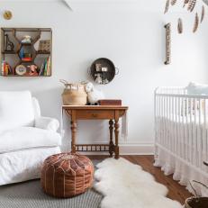 Quaint Nursery Features a Crib Nook and Bright White Walls