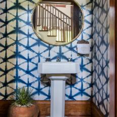 Colorful Bathroom Features Wallpaper and a Pedestal Sink