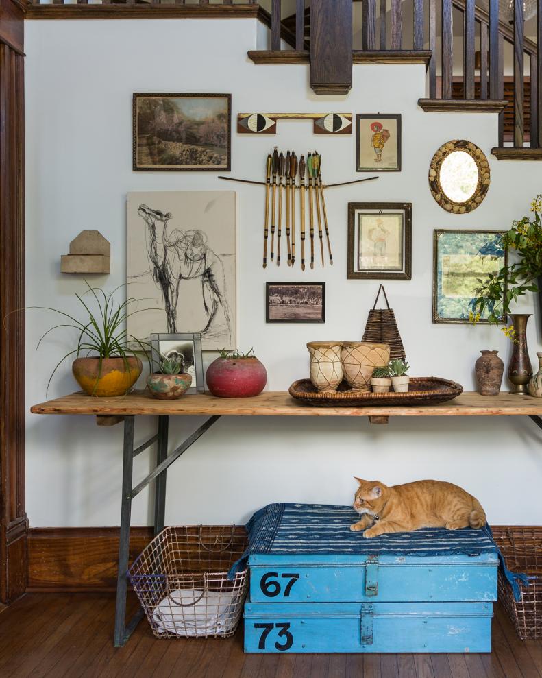 Various Artwork Hangs Above an Antique Table