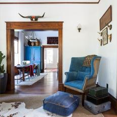 Rustic Living Space With a Blue Velvet Armchair and Cowhide Rug