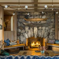 Rustic Cabin Family Room With Natural Stone Fireplace Surround and Exposed Beam Ceiling