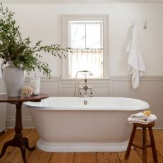 White Bathroom With Soaker Tub and Antique Wood Floors
