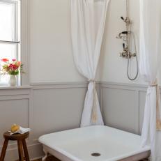 Crisp White Bathroom With Gray Wainscoting and Antique Shower