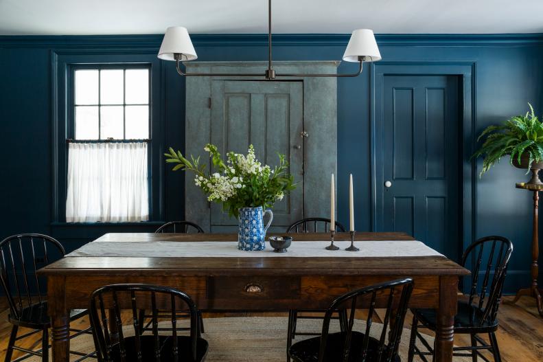 Blue dining room with 1900's chairs and custom light fixtures.