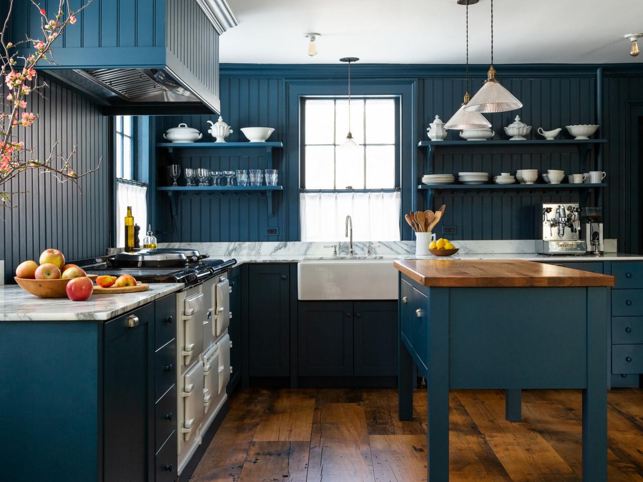 a bright kitchen with teal cabinets, mismatching tile backsplash, colorful  accessories…