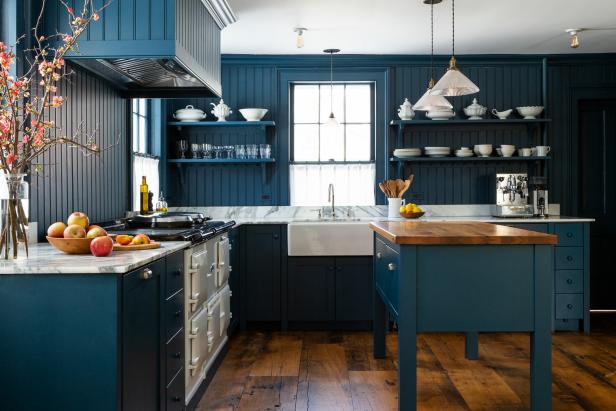 Striking country style blue kitchen with reclaimed wood floors.