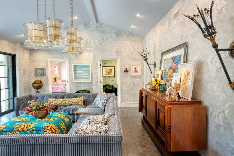Eclectic living room with blue U-shaped sofa and oversized sconces.