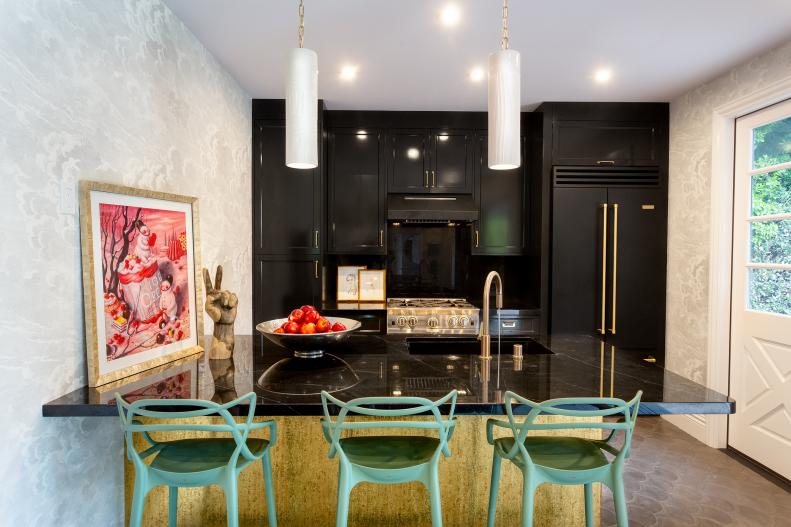 Kitchen with wall of black cabinets and eclectic blue bar stools. 