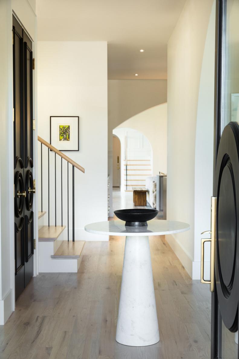 Black Front Door Open to Natural Hardwood Flooring, Neutral Wall Entry