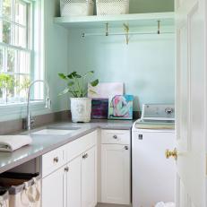 Throw-back Laundry Room With a Vintage Light Fixture and Wallpapered Ceilings