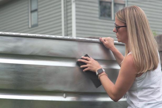 Use fine-to-medium grit sanding blocks to add grain to the exterior of the cleaned stock tank. This will ensure the primer adheres.