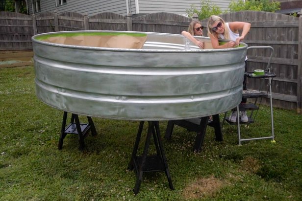 Cover and tape the inside of the pool with leftover craft paper to protect it from overflow spray paint. Next, add two coats of white primer to the outside of the tank. Tip: You will need 10-11 cans of primer white spray paint for an 8’ stock tank. Let the paint dry overnight.