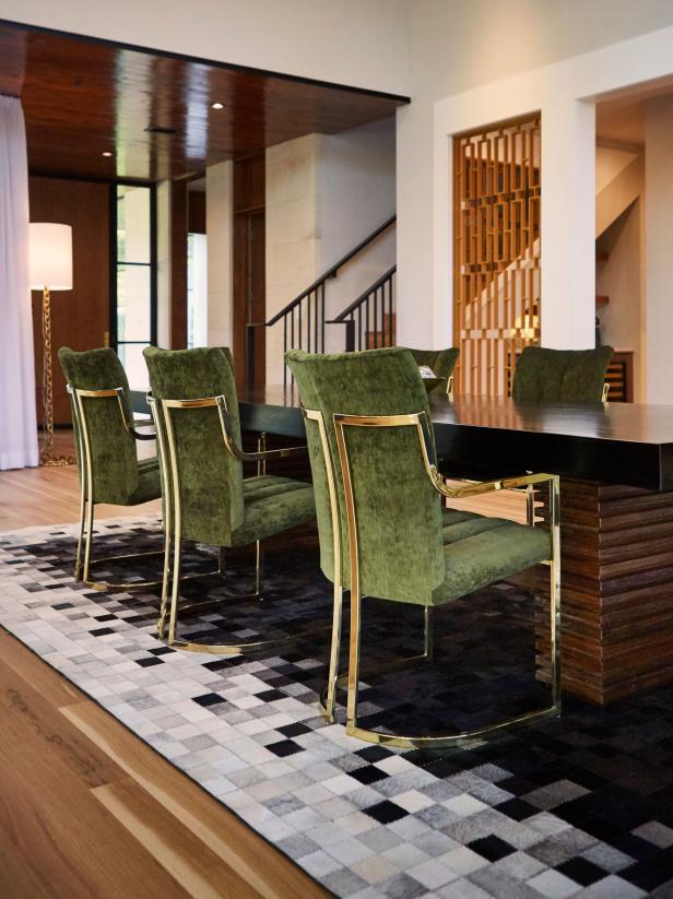 A midcentury dining room with elegant velvet green high-back chairs