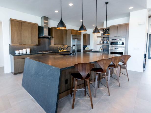 A black and gray midcentury kitchen with a cantilever island
