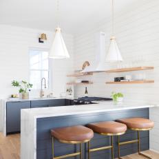 Contemporary White Kitchen With Marble Waterfall-Edge Peninsula, Shiplap and Floating Shelves 