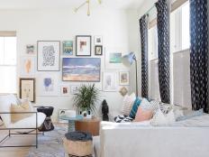White room with colorful art, small tables and white sectional.
