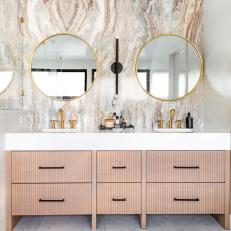 Double Vanity Bathroom With Gold Accents and a Marble Backsplash