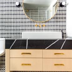 Modern Bathroom With Patterned Tile and a Gold Mirror