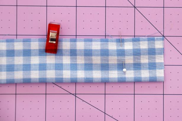 Cut your fabric to 22” x 3.5”. Fold it in half lengthwise with right sides together. Mark 1.5” from each end with a pin, and then pin or clip it together along the entire length.