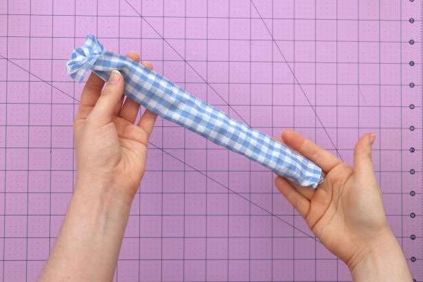 Attach a safety pin to the end of the tube and feed it through to turn it halfway inside out, so that the two short ends line up with each other.