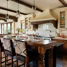 Airy and Vibrant Kitchen With Beautiful Range Hood and Upholsters Barstools