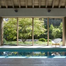 Contemporary Indoor Pool With Wide Windows, Exposed Beams and Modern Seat 